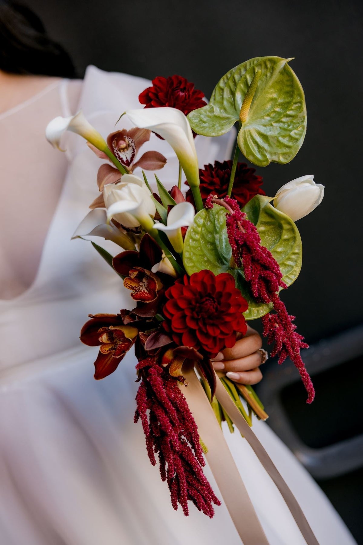 Bridal bouquet of red dahlias, white calla lilies, green anthurium and trailing amaranthus at Karen and Martin's Le Foote wedding